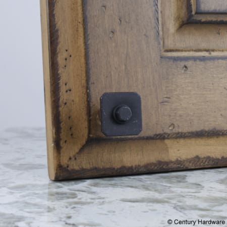 A large image of the Century 20223 Century-20223-Raw Authentic Knob in Matte Black Steel on Cabinet Door