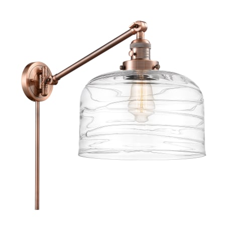 A large image of the Innovations Lighting 237-13-12-L Bell Sconce Antique Copper / Clear Deco Swirl