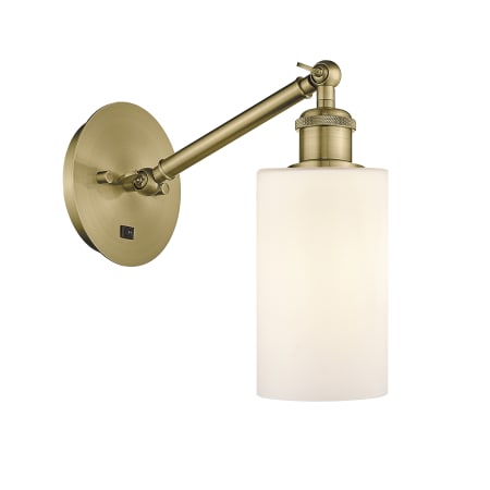 A large image of the Innovations Lighting 317-1W-13-6 Clymer Sconce Antique Brass / Matte White