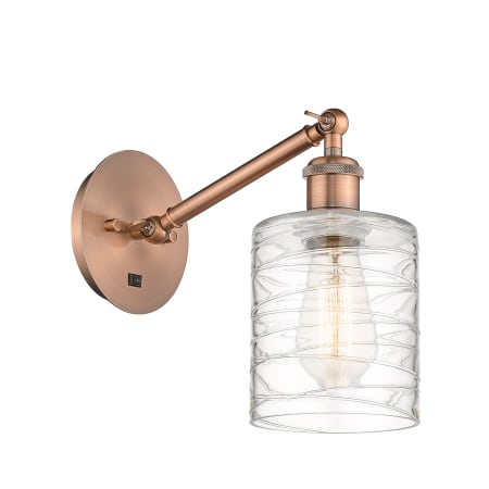 A large image of the Innovations Lighting 317-1W-13-6 Cobbleskill Sconce Antique Copper / Deco Swirl