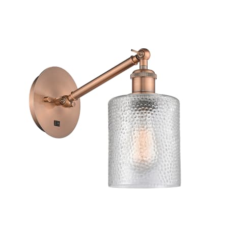 A large image of the Innovations Lighting 317-1W-13-5 Cobbleskill Sconce Antique Copper / Clear