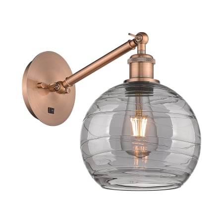 A large image of the Innovations Lighting 317-1W 10 8 Athens Deco Swirl Sconce Antique Copper / Light Smoke Deco Swirl