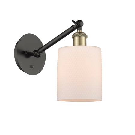 A large image of the Innovations Lighting 317-1W-13-6 Cobbleskill Sconce Black Antique Brass / Matte White