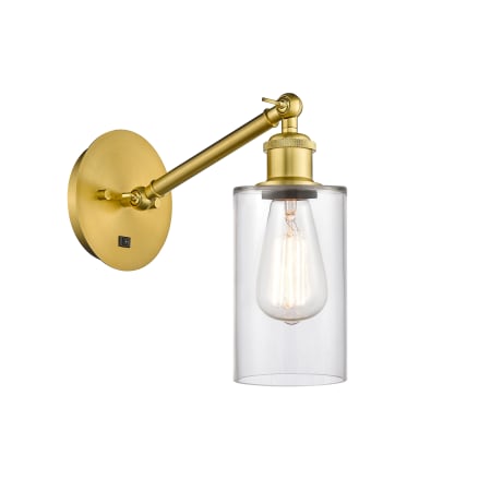 A large image of the Innovations Lighting 317-1W-13-5 Clymer Sconce Satin Gold / Clear