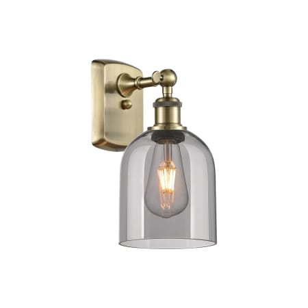 A large image of the Innovations Lighting 516-1W-11-6 Bella Sconce Antique Brass / Light Smoke