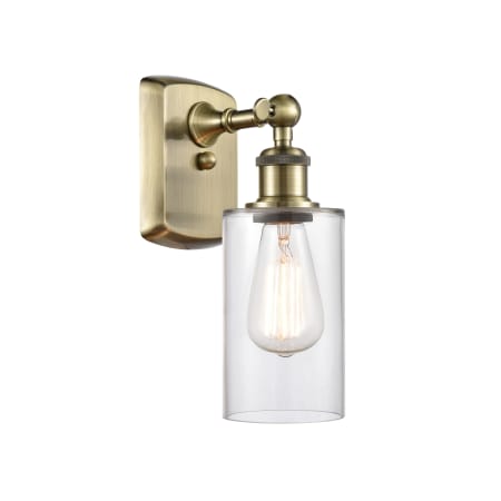 A large image of the Innovations Lighting 516-1W-12-4 Clymer Sconce Antique Brass / Clear