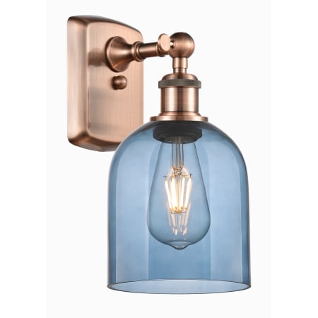 A large image of the Innovations Lighting 516-1W-11-6 Bella Sconce Antique Copper / Princess Blue