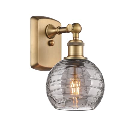 A large image of the Innovations Lighting 516-1W-10-6 Athens Deco Swirl Sconce Brushed Brass / Light Smoke Deco Swirl