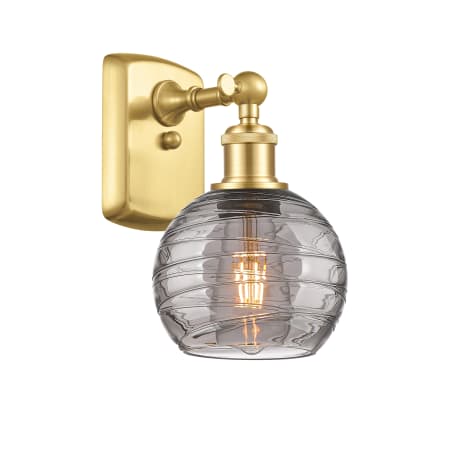 A large image of the Innovations Lighting 516-1W-10-6 Athens Deco Swirl Sconce Satin Gold / Light Smoke Deco Swirl