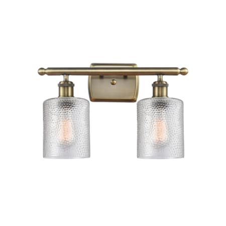 A large image of the Innovations Lighting 516-2W-9-16 Cobbleskill Vanity Clear / Antique Brass