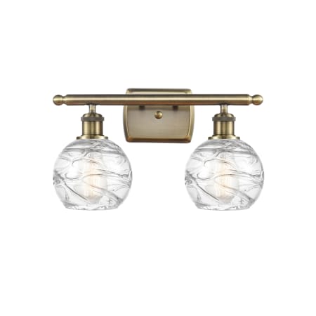 A large image of the Innovations Lighting 516-2W-11-16 Athens Vanity Antique Brass / Clear Deco Swirl