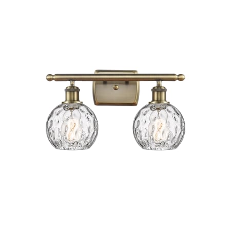 A large image of the Innovations Lighting 516-2W-11-16 Athens Vanity Antique Brass / Clear Water Glass