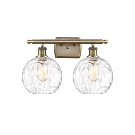 A large image of the Innovations Lighting 516-2W-13-18 Athens Vanity Antique Brass / Clear Water Glass