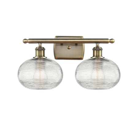 A large image of the Innovations Lighting 516-2W-10-18 Ithaca Vanity Antique Brass / Clear Ithaca