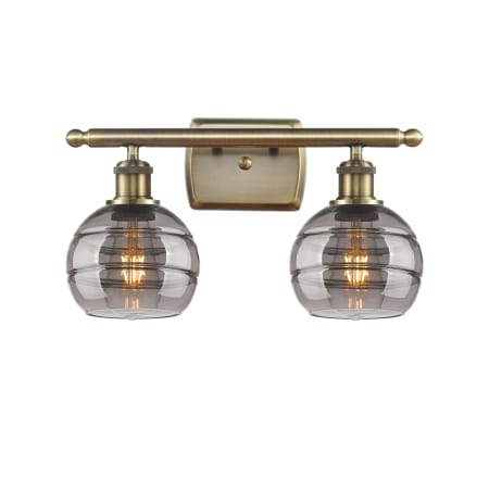 A large image of the Innovations Lighting 516-2W-9-16 Rochester Vanity Antique Brass / Light Smoke