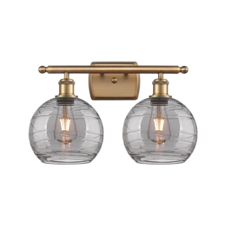 A large image of the Innovations Lighting 516-2W-11-18 Athens Deco Swirl Vanity Brushed Brass / Light Smoke Deco Swirl