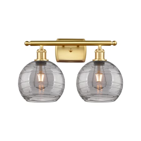 A large image of the Innovations Lighting 516-2W-11-18 Athens Deco Swirl Vanity Satin Gold / Light Smoke Deco Swirl