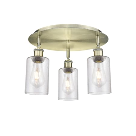 A large image of the Innovations Lighting 516-3C-10-16 Clymer Flush Antique Brass / Seedy