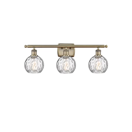 A large image of the Innovations Lighting 516-3W-11-26 Athens Vanity Antique Brass / Clear Water Glass