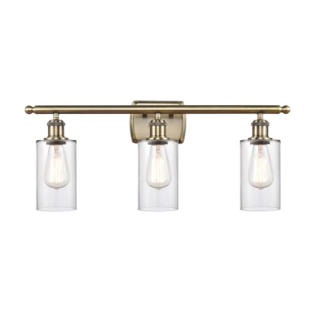 A large image of the Innovations Lighting 516-3W-12-26 Clymer Vanity Clear / Antique Brass