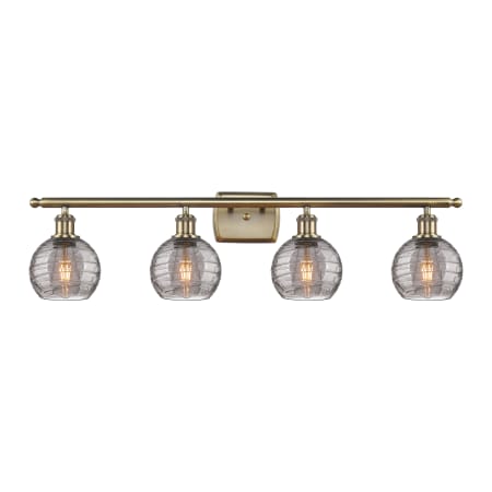 A large image of the Innovations Lighting 516-4W 9 36 Athens Deco Swirl Vanity Antique Brass / Light Smoke Deco Swirl