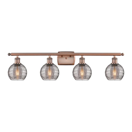 A large image of the Innovations Lighting 516-4W 9 36 Athens Deco Swirl Vanity Antique Copper / Light Smoke Deco Swirl