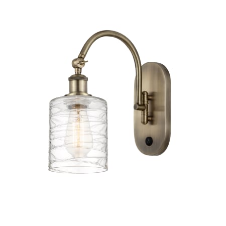 A large image of the Innovations Lighting 518-1W-13-6 Cobbleskill Sconce Antique Brass / Deco Swirl