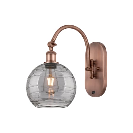 A large image of the Innovations Lighting 518-1W 13 8 Athens Deco Swirl Sconce Antique Copper / Light Smoke Deco Swirl