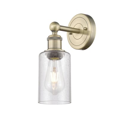 A large image of the Innovations Lighting 616-1W-11-4 Clymer Sconce Antique Brass / Seedy