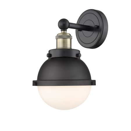 A large image of the Innovations Lighting 616-1W-12-7 Hampden Sconce Black Antique Brass / Matte Black / Matte White