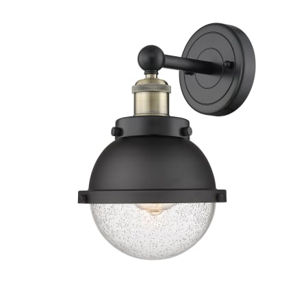 A large image of the Innovations Lighting 616-1W-12-7 Hampden Sconce Black Antique Brass / Matte Black / Seedy