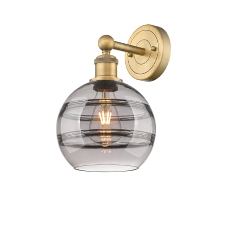 A large image of the Innovations Lighting 616-1W 12 8 Rochester Sconce Brushed Brass / Light Smoke