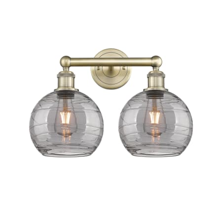 A large image of the Innovations Lighting 616-2W 12 17 Athens Deco Swirl Vanity Antique Brass / Light Smoke Deco Swirl