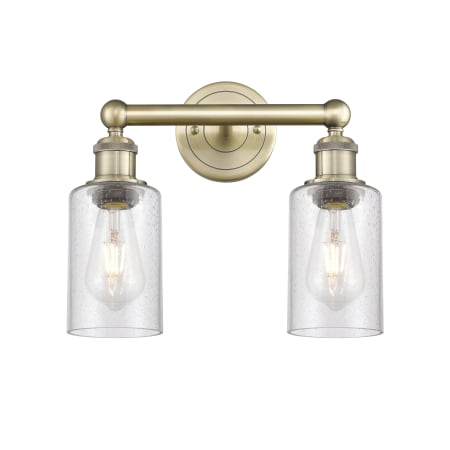 A large image of the Innovations Lighting 616-2W-11-13 Clymer Vanity Antique Brass / Seedy