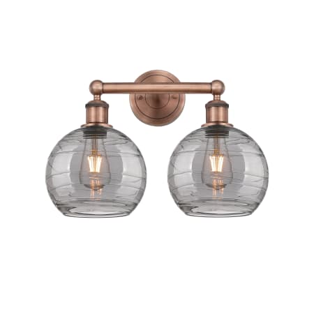 A large image of the Innovations Lighting 616-2W 12 17 Athens Deco Swirl Vanity Antique Copper / Light Smoke Deco Swirl