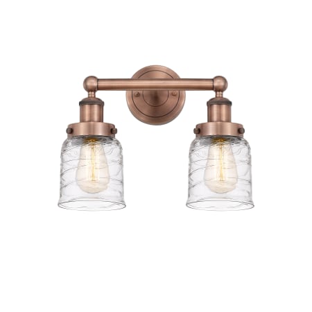 A large image of the Innovations Lighting 616-2W-10-16 Bell Vanity Antique Copper / Clear Deco Swirl