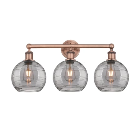 A large image of the Innovations Lighting 616-3W 12 26 Athens Deco Swirl Vanity Antique Copper / Light Smoke Deco Swirl