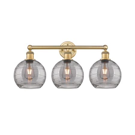 A large image of the Innovations Lighting 616-3W 12 26 Athens Deco Swirl Vanity Brushed Brass / Light Smoke Deco Swirl