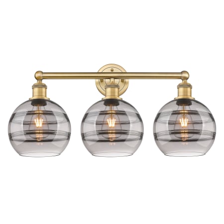 A large image of the Innovations Lighting 616-3W 12 26 Rochester Vanity Brushed Brass / Light Smoke