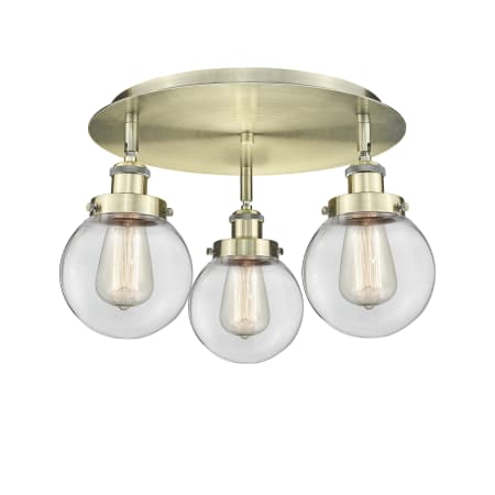 A large image of the Innovations Lighting 916-3C-10-18 Beacon Flush Antique Brass / Clear