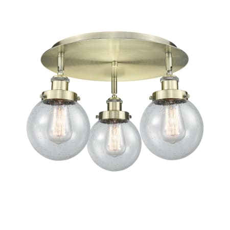 A large image of the Innovations Lighting 916-3C-10-18 Beacon Flush Antique Brass / Seedy