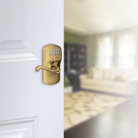A large image of the Schlage FE595-PLY-FLA Schlage's FE595-PLY-FLA in Antique Brass on door.