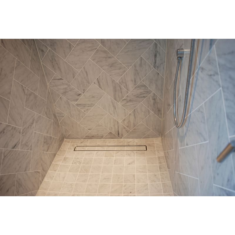 LUXE tile insert linear drain vanishes into the shower floor lending a  sleek design element to the contrasting tiles of the s…