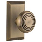Nostalgic Warehouse Deco Solid Brass Passage Door Knob Set with Studio Rose and 2-3/8" Backset Antique Brass