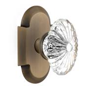 Nostalgic Warehouse Vintage Farmhouse Oval Fluted Crystal Flower Passage Door Knob Set with Solid Brass Cottage Style Plate and 2-3/8" Backset Antique Brass