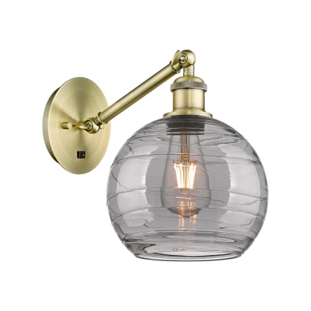 Innovations Lighting Athens Deco Swirl 10" Tall Swing Arm Wall Sconce Antique Brass / Light Smoke Deco Swirl