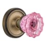 Nostalgic Warehouse Classic Solid Brass Rose Passage Door Knob Set with Pink Crystal Knob and 2-3/8" Backset Antique Brass