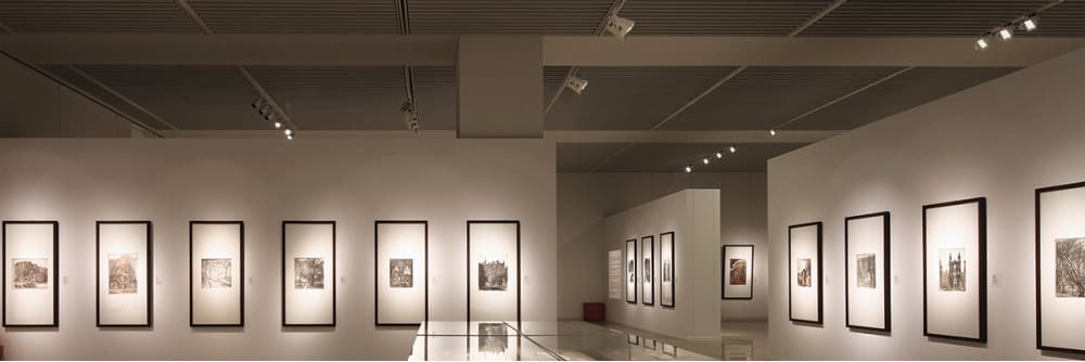 mushroom gray walls, artwork in black frames, illuminated walls