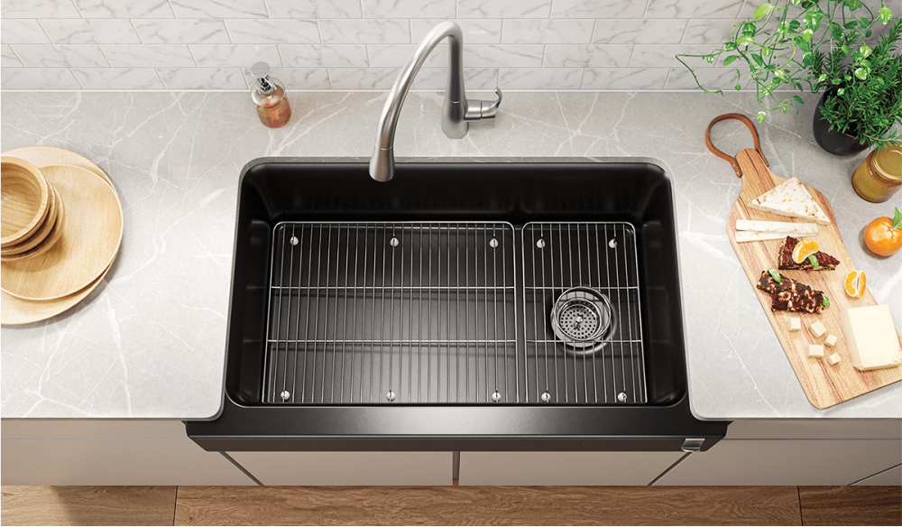 Black apron front sink with off-centered drain.