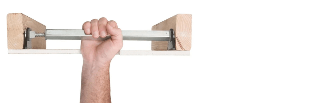 Hand installing brace into ceiling between two wood supports.